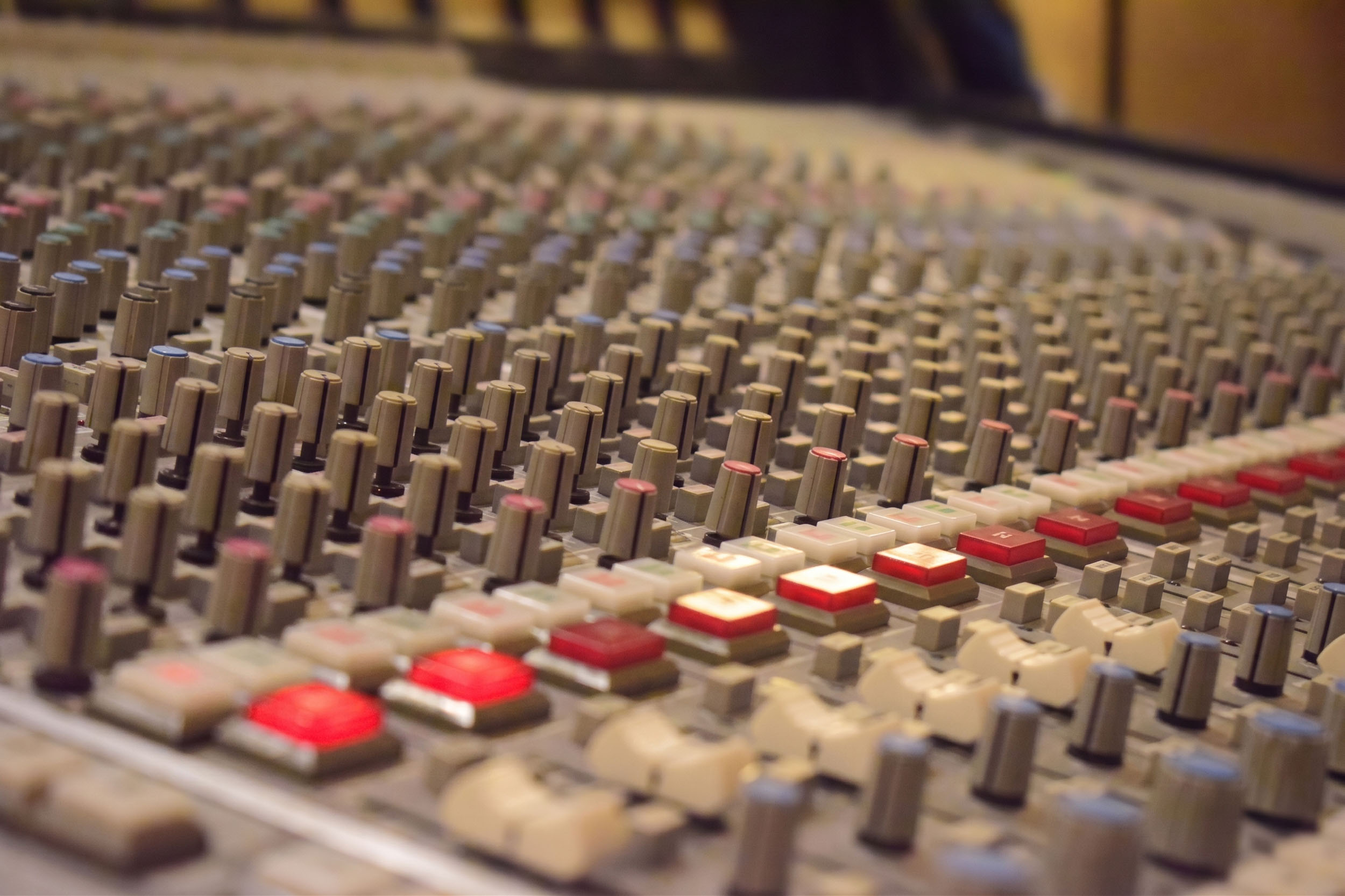 Close-up of SSL console faders and channel buttons at the ONLYMIXING studio